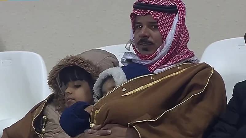 شاهد.. أب يحاول تدفئة نجله الصغير من البرد في مباراة الباطن والاتحاد