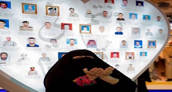 بالصورة.. امرأة مسنة تتأمل لوحة شرف شهداء الوطن بالجنادرية