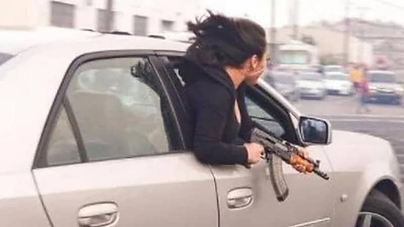 فتاة تحمل "كلاشينكوف" وتخرج جسدها من سيارة مسرعة تثير الجدل