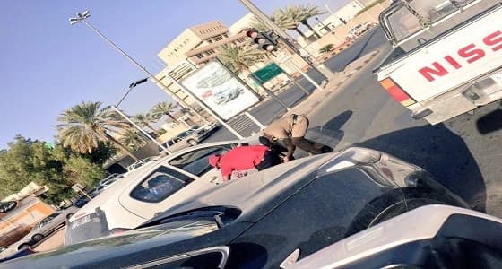 بالصور.. رجل أمن يساعد عامل في إصلاح إطار مركبته بحائل