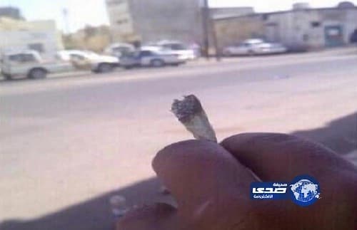 مغردون يتناقلون صورة لشخص يمسك بسيجارة "حشيش" أمام الدوريات في تبوك
