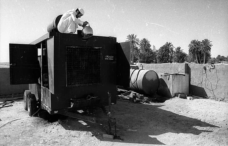 صورة قديمة لفني يستخدم إبريقاً لتبريد أحد المولدات