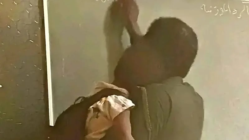 أستاذ جامعي يحمل طفله على كتفه أثناء تدريس طلابه بكلية الهندسة