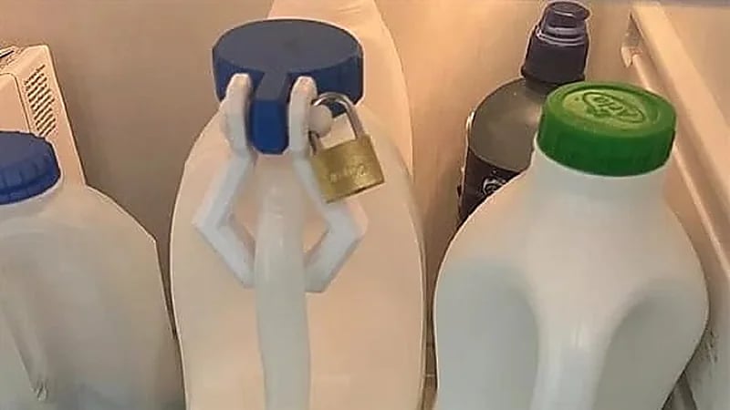 رجل يغلق زجاجة حليب بـ قفل في محل عمله